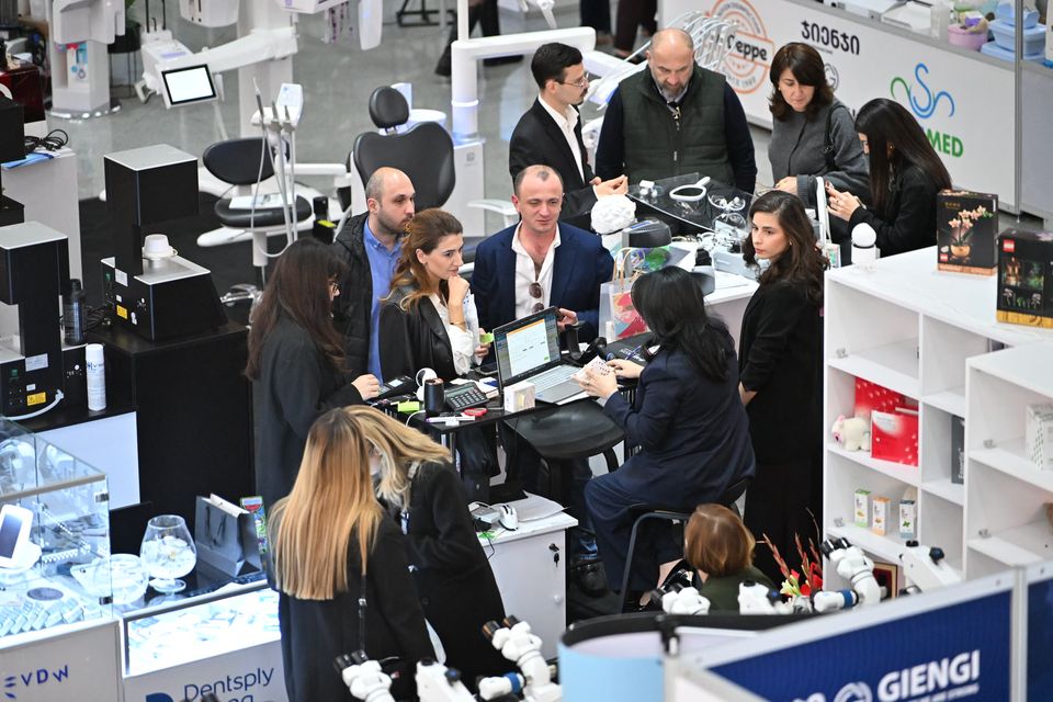 A busy stand seen from above, visitors talking with exhibitors