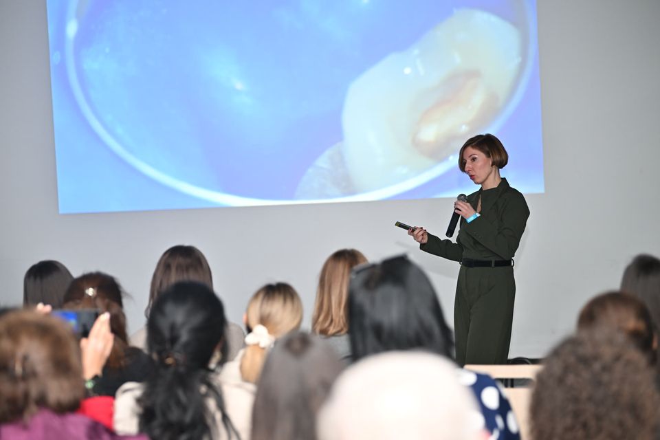 A speaker presenting a clinical case to a full audience